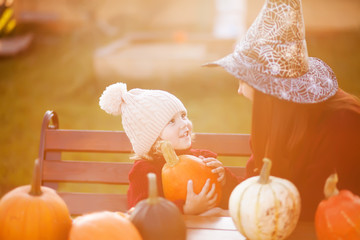 Fototapeta na wymiar Mother and child choosing pumpkins for jack-o-lantern.
