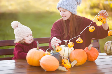 Mother and child choosing pumpkins for jack-o-lantern.