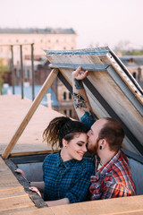 Romantic date on roof. Love couple closeup. Movie scene, gentle relationships. Happy and young smiley people in focus on foreground, urban background
