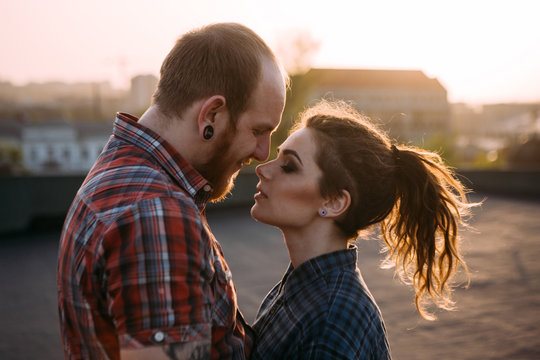 Tender couple cuddle. Relationships background. Passion young people together on roof closeup, atmospheric backlight with focus on foreground, love on top of the world concept