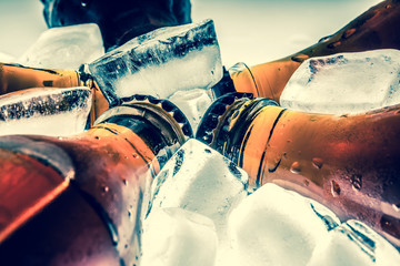 Soda glass bottles in a refrigerated ice cubes on a light background. Retro old style vintage...