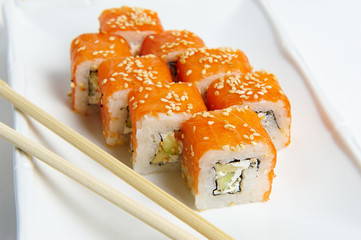 Philadelphia rolls on a white plate with chopsticks. with salmon, shrimp, avocado, cream cheese. Sushi menu. Japanese food.
