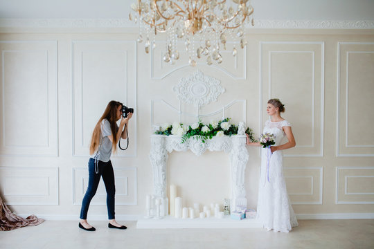 Photographer with long hair is taking pictures the young sexy bride