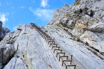 In der vertikalen Kalksteinwand eines Klettersteigs angebrachte Stahl-Steighilfen (Klammern)