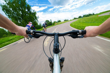 Rider driving bicycle on an asphalt road.