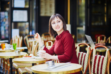 Woman drinking coffee in Parisian outdoor cafe