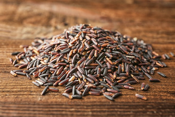Heap of wild rice on wooden background