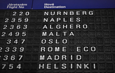 Obraz premium Departures board at the airport. Flight information mechanical timetable. Split flap mechanical departures board. Flight schedule