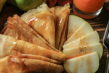 Tasty thin pancakes with pears on plate, closeup