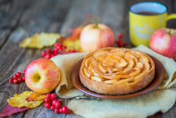 Apple pie on a wooden texture with red berries