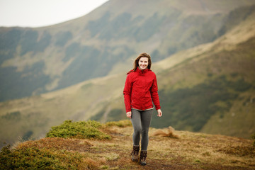 Naklejka premium Shot of a young woman looking at the landscape while hiking in the mountains. Girl tourist in mountain. Recreation fitness and healthy lifestyle outdoors in beautiful nature