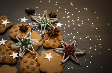 Christmas gingerbread cookies with xmas ornaments on dark background 
