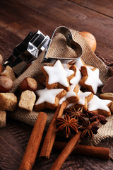 Christmas cookies and spices on brown wooden background.