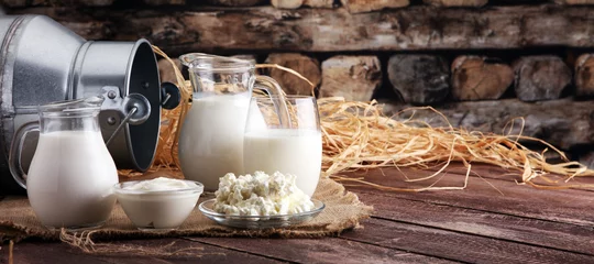 Wall murals Dairy products milk products. tasty healthy dairy products on a table on. sour cream in a bowl, cottage cheese bowl, cream in a a bank and milk jar, glass bottle and in a glass