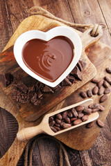 Chocolate cream melted and chocolate pieces on wooden table