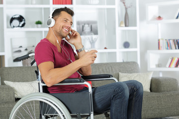 man happy in a wheelchair listening to music