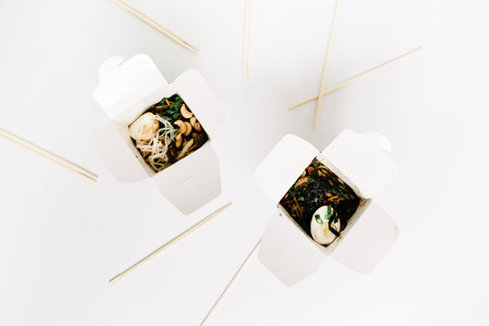 Noodles In Box And Chopsticks On White Background. Flat Lay, Top View. Chinese Takeaway Food Concept.