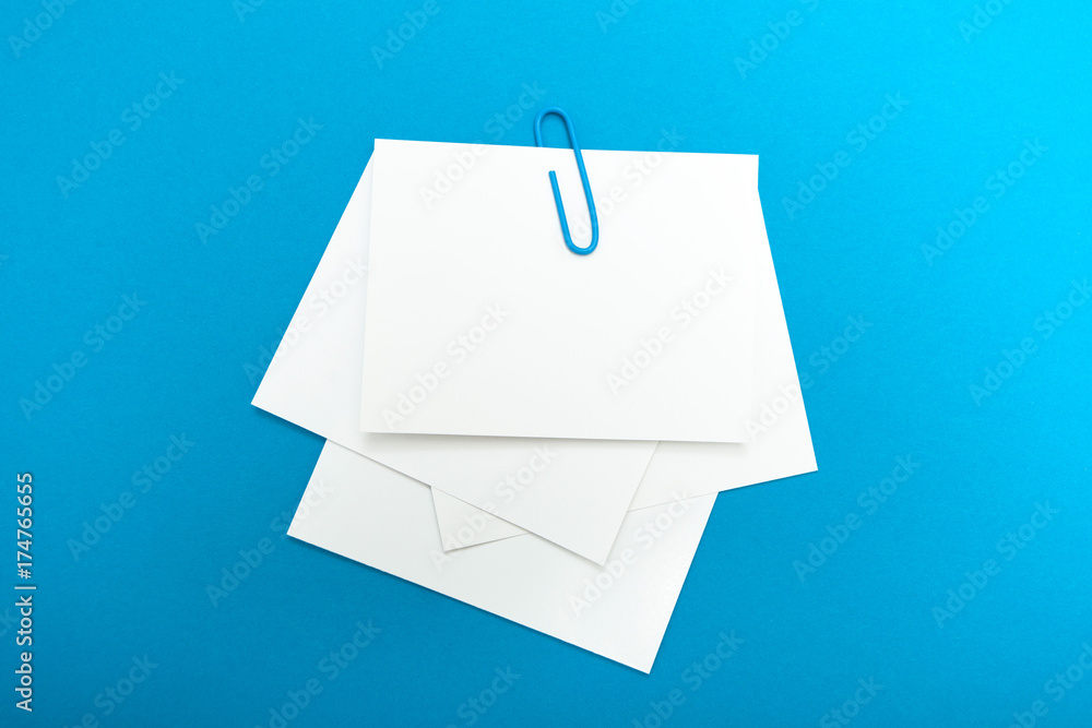 Aufkleber a set of a memorable paper note connected by a paper clip on a blue background. an empty layout.