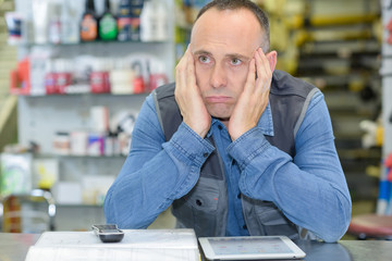 senior warehouse worker having a headache