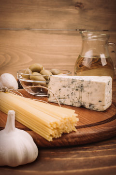 Food ingredients for preparing pasta on wooden kitchen board