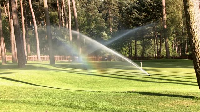 Sprinklers on a golf course cause a rainbow effect