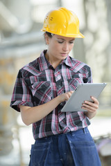 Fototapeta premium female contractor at a work site using an ipadtablet