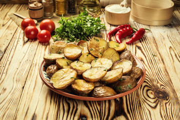 Close up of steaming hot baked potato,Hot buttered jacket baked potatoes,Roasted potato in bowl on wooden table,Oven-baked potatoes with sea salt and rosemary,toasted baked potato strewed with herbs.