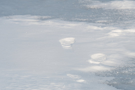 footprints in the snow on frozen lake