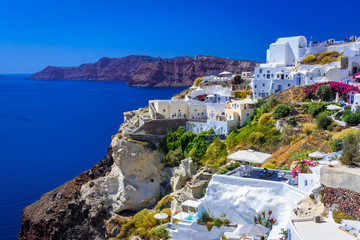 Oia, Santorini island, Greece. Traditional and famous white houses and churches  with blue domes over the Caldera, Aegean sea.