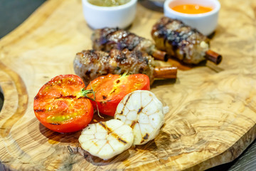 Grilled tomatoes, garlic and kebabs are on the Board.