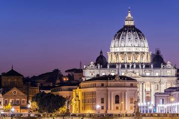 Rome, Italy. Vatican dome of Saint Peter Basilica (San Pietro) and Sant'Angelo Bridge, over Tiber river at dusk. One of the most famous view in the World