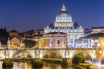 Fototapeta na wymiar Rome, Italy. Vatican dome of Saint Peter Basilica (San Pietro) and Sant'Angelo Bridge, over Tiber river at dusk. One of the most famous view in the World