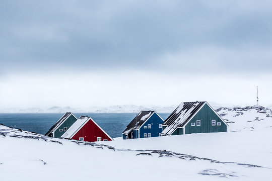 Four colorful inuit houses among therocks in a suburb of arctic capital Nuuk, Greenland