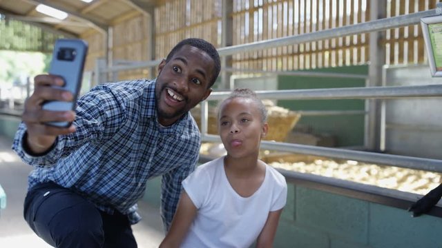  Happy father & daughter at community farm pose for selfie with camera phone