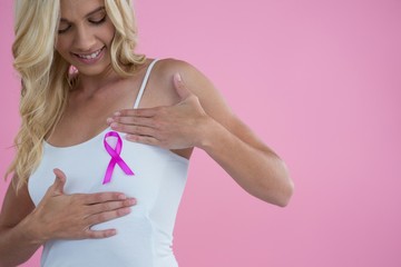 Smiling woman touching breast while looking Breast Cancer