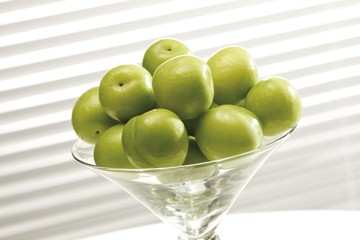 Green plums in a glass