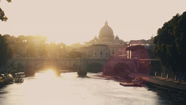 Video of a wonderful view of sunset coming down behind the great St. Peter's Basilica in Rome, Italy. Video shot from a bridge over the Tiber river.