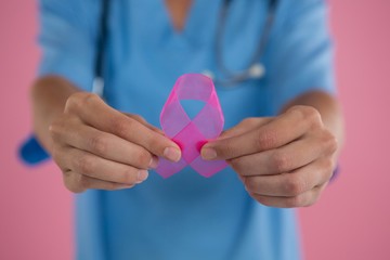 Mid section of female doctor in scrubs showing Breast Cancer