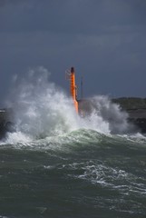 Fototapeta na wymiar Strong waves with spray in a storm at the pier of Hvide Sande, Jutland, Denmark, Europe