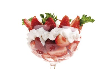 Strawberries, whipped cream and mint leaves in a glass