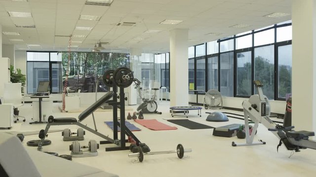Interior of empty modern gym with video screen showing moving outdoor scene