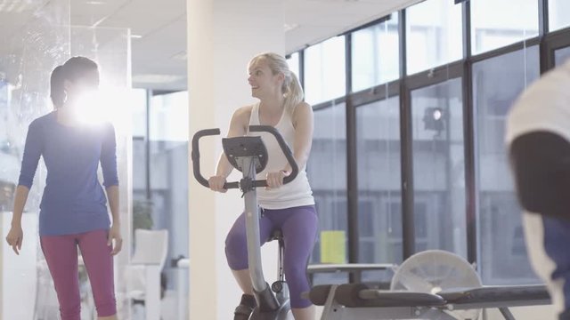 Fit group working out in the gym, video screen showing moving outdoor scene