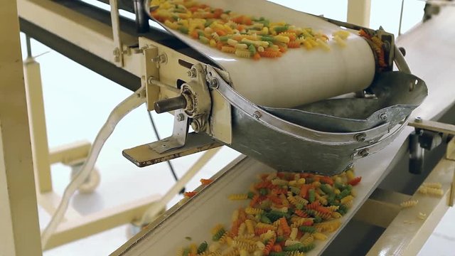 Tricolor Fusilli Pasta on Industrial Conveyor Belt, Food Processing Line - Close Up