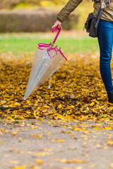 Naklejka premium Woman walking in park with umbrella