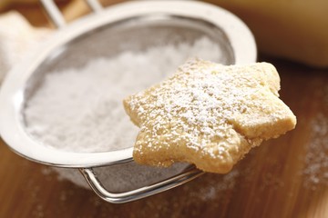 Star-shaped shortcrust cookie with powdered sugar on sieve