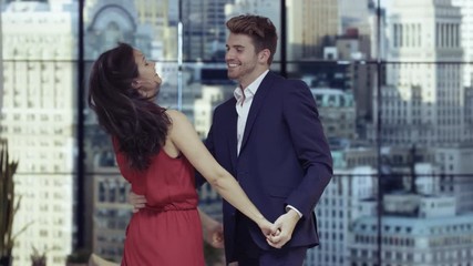  Young romantic couple dancing by the window in New York City apartment