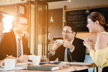 A group of men are businessmen sit together and succeeded in finding the various agreements.