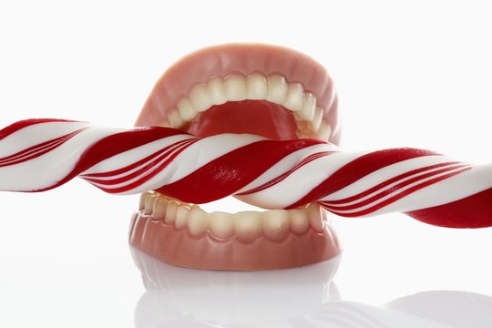 Candy cane and dentures, symbolic image for caries