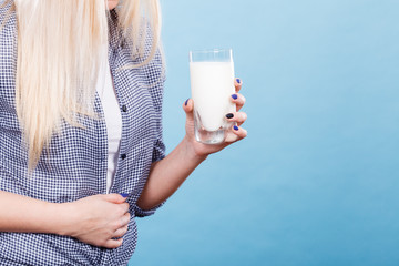 Woman holding milk glass having stomach ache