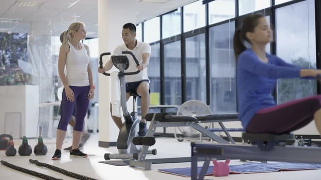 Fit group working out in the gym, video screen showing moving outdoor scene